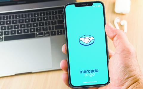 Male hand holding a smartphone with Mercado Pago app on the screen. Office environment. Rio de Janeiro, RJ, Brazil. January 2022.