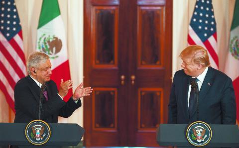 US President Donald Trump smiles as Mexican President Andres Manuel Lopez Obrador applauds him as they speak before a working dinner the White House on July 8, 2020, in Washington, DC. (Photo by JIM WATSON / AFP)