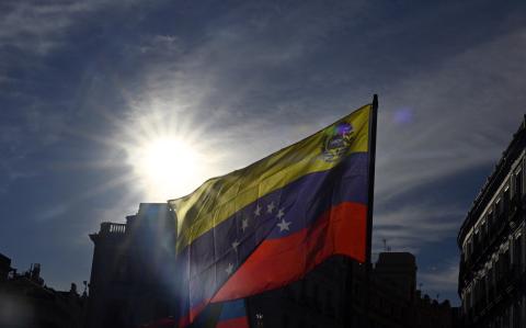 Los manifestantes ondean banderas venezolanas durante una marcha después de un llamado a protestas globales contra los resultados de las disputadas elecciones en Venezuela.