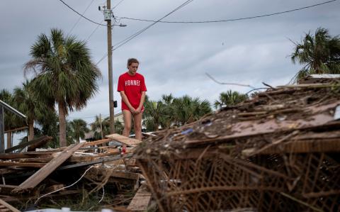 Piper Wagenman se encuentra entre los escombros de la casa de playa de su familia, luego del huracán Helene en Horseshoe Beach, Florida.