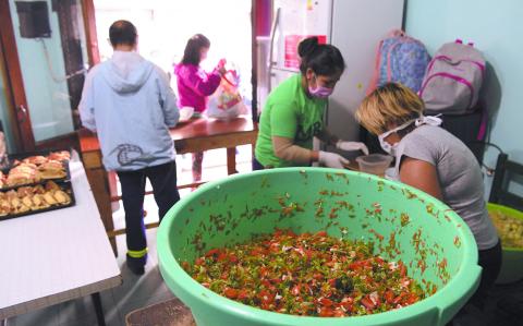 Volunteers prepare food at a community kitchen of the MRP (Movimiento Resistencia Popular) during the lockdown imposed by the government against the spread of the new coronavirus, COVID-19, at La Boca neighborhood in Buenos Aires, Argentina, on April 22, 2020. (Photo by JUAN MABROMATA / AFP)