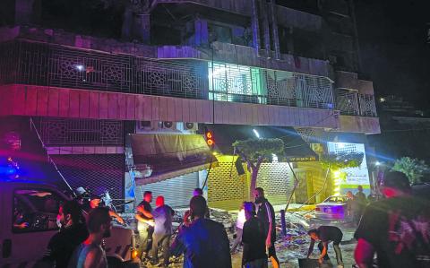 People gather at the site of an Israeli airstrike that targeted an apartment building in Beirut's Bashura neighborhood on October 3, 2024. (Photo by Ibrahim AMRO / AFP)