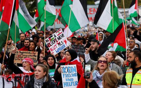 Manifestantes en Berlín sostienen pancartas y banderas palestinas durante una manifestación de solidaridad con los palestinos en Gaza.