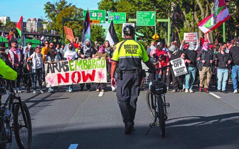 Police look on as pro-Palestinian demonstrators march during a rally to mark one year of the war between Hamas and Israel in Boston, Massachusetts on October 6, 2024. (Photo by Joseph Prezioso / AFP)