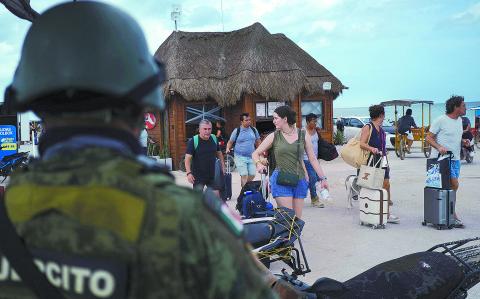 A member of the Mexican Army watches while residents and tourists heed a voluntary evacuation call as Hurricane Milton advances, on the island of Holbox, Mexico, October 7, 2024. REUTERS/Paola Chiomante