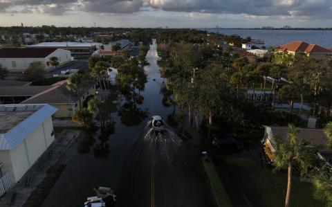 La vista de un dron muestra un automóvil conduciendo por una calle inundada después de que el huracán Milton tocara tierra en South Daytona, Florida.