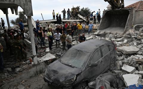 Personas inspeccionan los daños que dejó un ataque aéreo israelí en una aldea de Líbano.