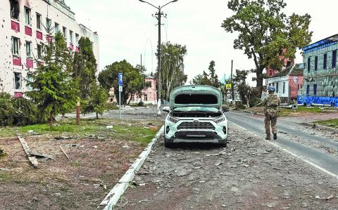 FILE PHOTO: A Ukrainian serviceman patrols a street next to buildings, damaged during recent fighting between Ukrainian and Russian forces in controlled by Ukrainian army the town of Sudzha, Kursk region, Russia August 16, 2024. REUTERS/Yan Dobronosov/File Photo