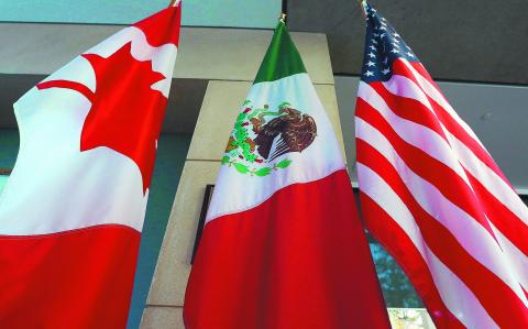 (FILES) This file photo taken on September 24, 2017 shows the Mexican, US and  Canadian flags in the lobby where the third round of the NAFTA renegotiations took place in Ottawa, Ontario.
Canada announced on January 23, 2018 it will sign on the Trans Pacific Partnership, moving to diversify its trade relationships  as Canadian, US and Mexican negotiators kicked off a sixth round of talks on a 1994 free trade pact that Washington has threatened to dump. Canada had initially balked at joining the proposed TPP last year, acting as the main holdout in negotiations after US President Donald Trump decided in early 2017 to go it alone under his "America First" policy.
 / AFP PHOTO / Lars Hagberg