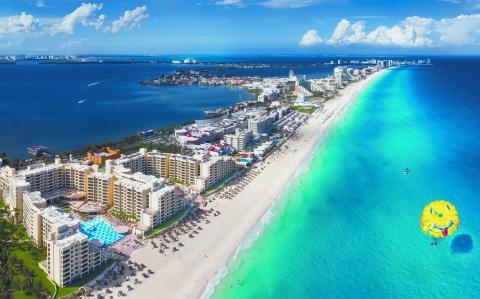 Cancun beach with para sailing over water