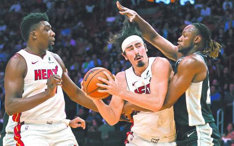 Oct 15, 2024; Miami, Florida, USA; Miami Heat guard Jaime Jaquez Jr. (11) drives to the basket against San Antonio Spurs center Charles Bassey (28) during the third quarter at Kaseya Center. Mandatory Credit: Sam Navarro-Imagn Images