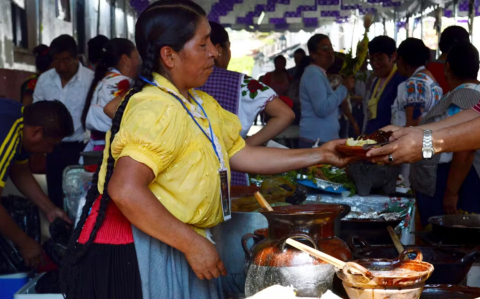 Mujer sirviendo corundas en el Tianguis de Domingo de Ramos en Uruapan, Michoacán, México.