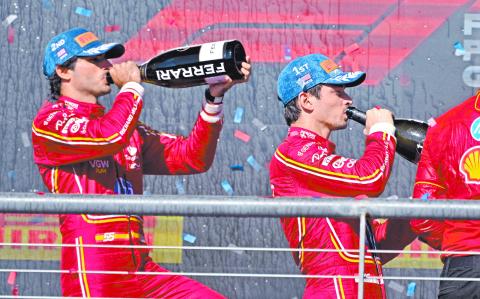 Oct 20, 2024; Austin, Texas, USA; Scuderia Ferrari driver Carlos Sainz (left) of Team Spain and Scuderia Ferrari driver Charles Leclerc (right) of Team Monaco drink champagne on the podium after the 2024 Formula One US Grand Prix at Circuit of the Americas. Mandatory Credit: Jerome Miron-Imagn Images