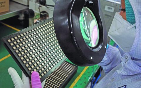 FILE PHOTO: A worker inspects semiconductor chips at the chip packaging firm Unisem (M) Berhad plant in Ipoh, Malaysia October 15, 2021. REUTERS/Lim Huey Teng/File Photo