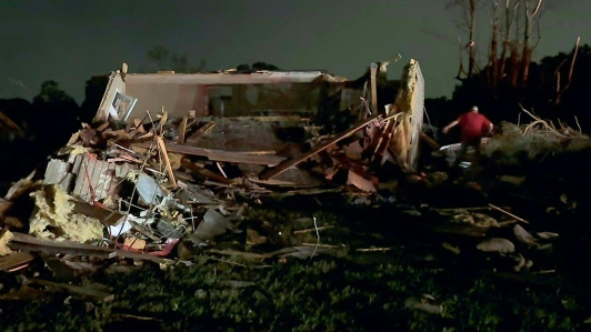 Residentes locales buscan entre los daños causados ​​por el tornado.