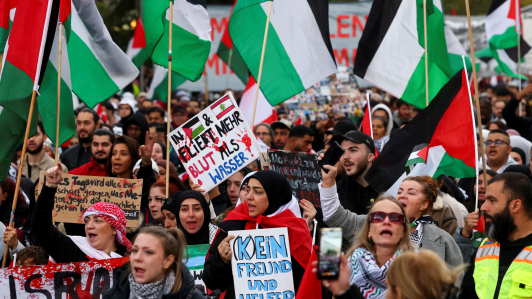 Manifestantes en Berlín sostienen pancartas y banderas palestinas durante una manifestación de solidaridad con los palestinos en Gaza.