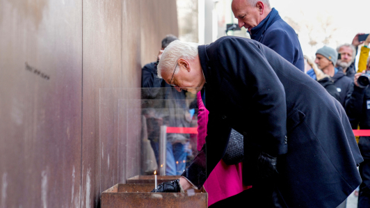 El presidente alemán, Frank-Walter Steinmeier, enciende una vela con motivo del 35º aniversario del muro en Berlín.