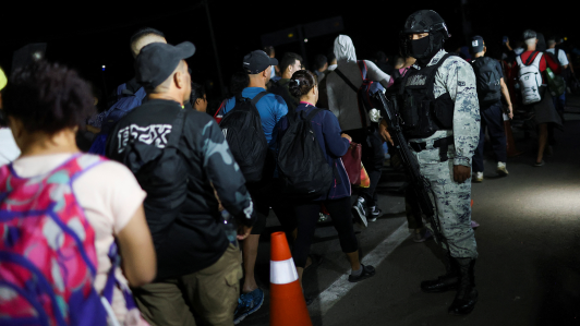 Efectivos de Guardia Nacional Mexicana vigilan a migrantes que pasan por Tapachula, México.