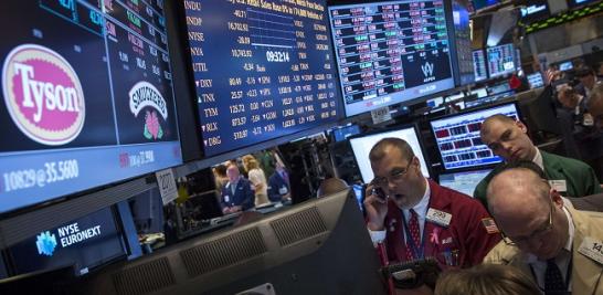 Traders gather at the post that trades Tyson Foods on the floor of the New York Stock Exchange