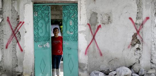 Nadia Rosas se encuentra dentro de la casa de su tía cubierta con símbolos de pintura en aerosol que la designan condenada, después de que fue destruida por un terremoto en Atzala, México.