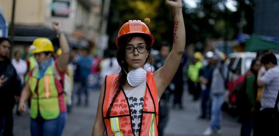 Isabel Campana, de 28 años, sostiene un puño cerrado como un gesto para mantener el silencio fuera de un edificio derrumbado después de un terremoto en la Ciudad de México. Campana dijo que estaba filmando una película cuando ella y su equipo sintieron el terremoto.