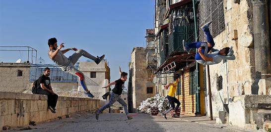 El grupo de "traceurs" (practicantes de parkour) práctica desde 2014 este deporte que combina figuras acrobáticas y saltos para desplazarse de un punto a otro en jardines, gimnasios y sitios públicos de esta ciudad situada en el norte del país en guerra.