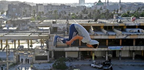 En una calle cubierta de arena y escombros, jóvenes salen volando por los aires para caer unos metros más lejos y volver a despegar.