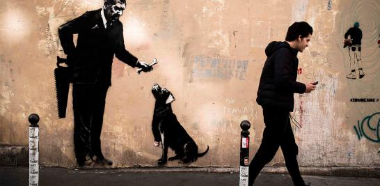 Esta obra apareció al lado de la Sorbona, en Paris. El hombre de la imagen entusiasma con un hueso a un perro al que le acaban de amputar la pierna... mientras esconde la sierra a sus espaldas.