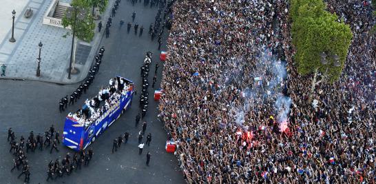 Miles de personas esperan bajo el Arco del Triunfo la llegada de la selección francesa para celebrar el campeonato del mundo.