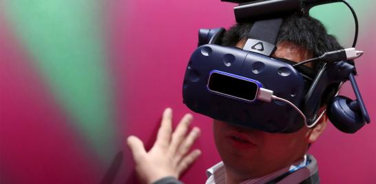 Un hombre revisa un dispositivo de realidad virtual dentro del stand de Deutsche Telekom.