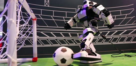 Robot patea una pelota de futbol dentro de un stand de Huawei en el en el MWC 2019.