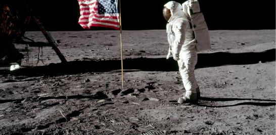 Imagen del primer hombre en pisar la luna. El astronauta Buzz Aldrin posa para una fotografía con la bandera de los Estados Unidos clavada en la Luna el 20 de julio de 1969, durante la actividad extravehicular en la misión del Apolo 11. El módulo lunar está a la izquierda y las huellas de los astronautas son visibles en el suelo.