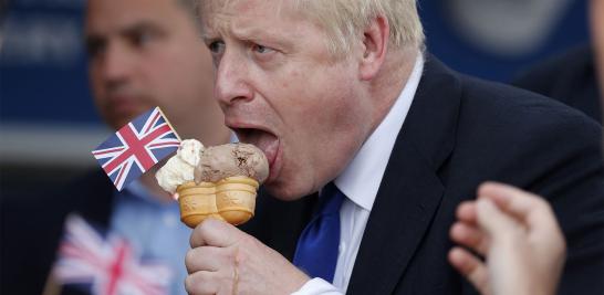 En esta foto tomada el 6 de julio de 2019, el diputado conservador y contendiente de liderazgo Boris Johnson prueba un helado mientras hace campaña en Barry Island, al oeste de Cardiff, en el sur de Gales.