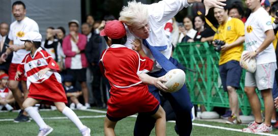 El alcalde Boris Johnson de Londres, durante un juego de Street Rugby con un grupo de niños de Tokio, en las afueras del edificio Tokyo Square Gardens, 15 de octubre de 2015. 