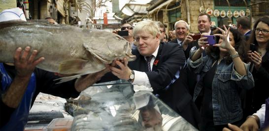 El alcalde Boris Johnson, mira un pez mientras recorre el mercado Mahane Yehuda en Jerusalén el 10 de noviembre de 2015.