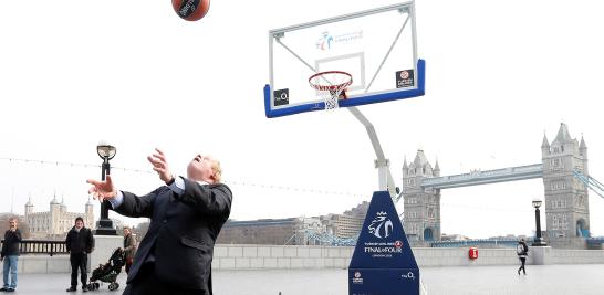 El alcalde de Londres, Boris Johnson, dispara y anota de espaldas a la canasta en Londres el 8 de abril de 2013.