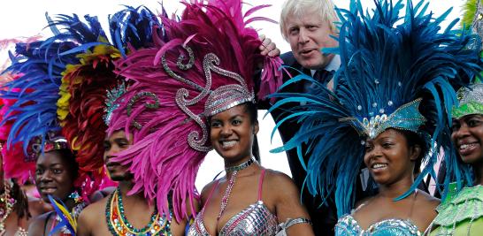 El alcalde de Londres, Boris Johnson, se une a las bailarinas en una sesión de fotos para promover el Carnaval de Notting Hill en el Ayuntamiento en Londres el 24 de agosto de 2011.