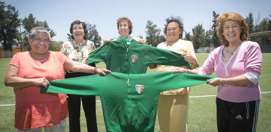 Yolanda Ramírez, Irma Chávez, Alicia Vargas, Elvira Aracén y Lourdes de la Rosa sostienen esas chamarras de paño que tanto calor les provocaba. Minutos antes de abordar el avión a Italia, rumbo al primer mundial, les llegó la donación de estas chaquetas. Foto: Lizeth Arauz