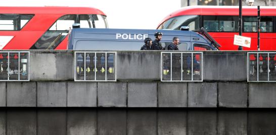 Police officers and emergency staff work at the site of an incident at London Bridge