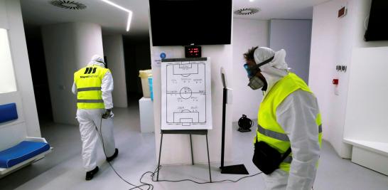 Cleaners wearing protective suits sanitise locker rooms at the San Paolo stadium ahead of the second leg of the Coppa Italia semi-final between Napoli and Inter Milan, which has since been postponed