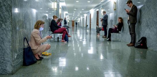 Periodistas practican el distanciamiento social fuera de una reunión para concluir el trabajo sobre la legislación de ayuda económica del coronavirus en Washington.