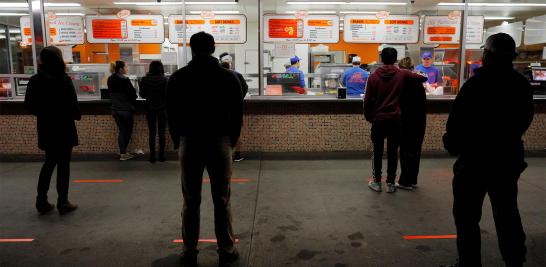 Las líneas en el suelo ayudan a los clientes a mantener seis pies de distancia social segura en Dick's Drive-In en Seattle, Washington.