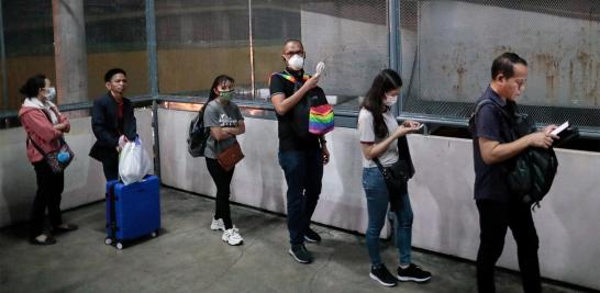 Las personas mantienen el distanciamiento social mientras hacen fila para subirse a un tren en la ciudad de Quezon, Metro Manila, Filipinas.