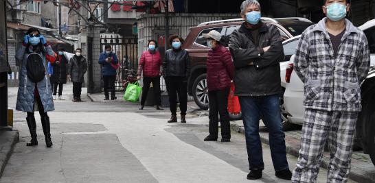 Los residentes hacen fila para recolectar vegetales comprados a través de pedidos grupales en un área residencial en Wuhan, el epicentro del brote de coronavirus, en la provincia china de Hubei.