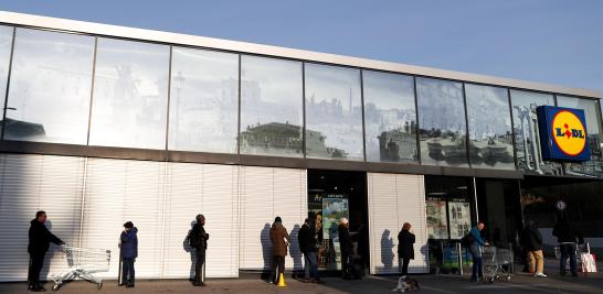 La gente hace cola en un supermercado para abastecerse de alimentos y bienes en Roma, Italia.