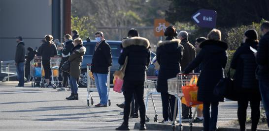 Las personas hacen cola frente a un supermercado Sainsbury's en el suroeste de Londres, Gran Bretaña.