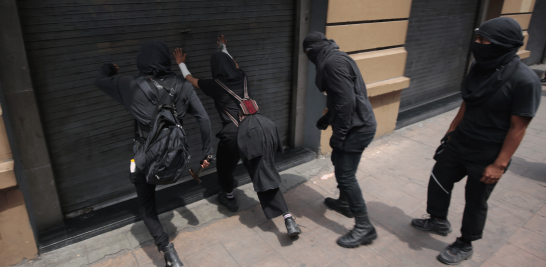 A su paso por la calle 5 de Mayo, los manifestantes se encontraron con diversos comercios cerrados y resguardados para evitar agresiones. Foto EE: Eric Lugo