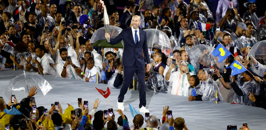 El exfutbolista y entrenador Zinedine Zidane fue el primero en realizar el recorrido de la llama olímpica desde el escenario donde se proclamó el inicio de los Juegos. Foto: Reuters