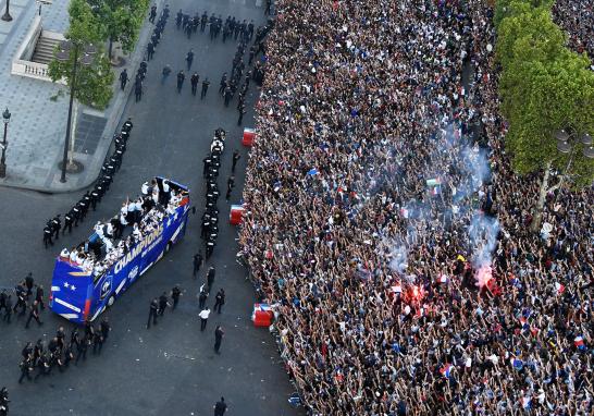 Miles de personas esperan bajo el Arco del Triunfo la llegada de la selección francesa para celebrar el campeonato del mundo.