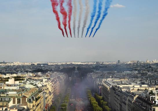 La Patrulla de Francia también celebra el regreso de los campeones del mundo dejando el rastro de los colores de la bandera nacional sobre los Campos Elíseos mientras los aficionados dan la bienvenida a los jugadores.